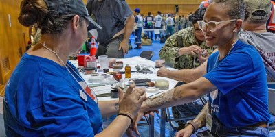 An American Red Cross Yokosuka volunteer applies moulage to a role player during Big Rescue Kanagawa 2026 at the Kanagawa Prefectural Comprehensive Disaster Prevention Center and Fire Academy.