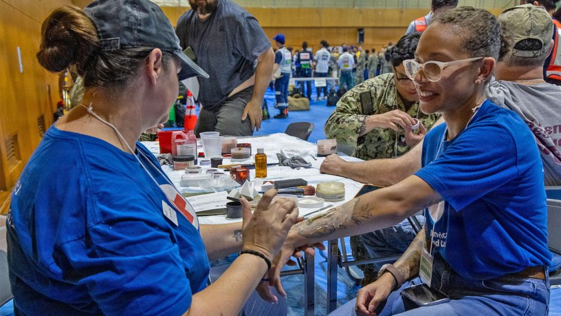 An American Red Cross Yokosuka volunteer applies moulage to a role player during Big Rescue Kanagawa 2026 at the Kanagawa Prefectural Comprehensive Disaster Prevention Center and Fire Academy.