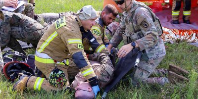 Polish military firefighters and U.S. Army medics from the 928th Medical Company, Area Support, treat the simulated injuries of a U.S. Soldier assigned to the 1st Infantry Division, roleplaying as a plane crash survivor during a joint U.S.-Polish (USPOL) mass casualty exercise, Sept. 2, 2026 in Powidz, Poland.