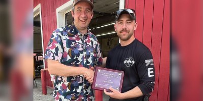 Denali Borough Mayor Chris Noel, left, congratulates Staff Sgt. Nathaniel Grimes, chief of the Anderson Volunteer Fire Department, after presenting him with the 2026 Denali Borough Mayor’s Community Service Award during the Anderson Strawberry Festival in Anderson, Alaska, July 11, 2026.