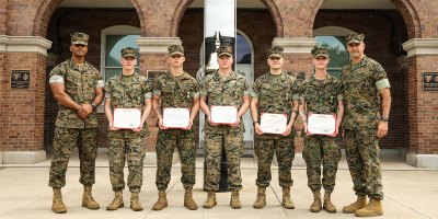 U.S. Marines with Guard Company, Marine Barracks Washington pose for a photo with Sgt. Maj. Juan P. Segura, sergeant major, Marine Barracks Washington, left, and Col. Jason Copeland, commanding officer of Marine Barracks Washington, right, after an award ceremony at Marine Barracks Washington, D.C., Sept. 3, 2026.