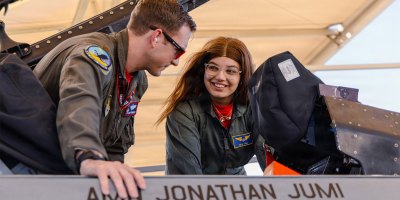 Air Force Maj. Michael Grimmer, a pilot assigned to the 416th Flight Test Squadron, shows an F-16 Fighting Falcon to Hailey Macleod, an honorary pilot, at Edwards Air Force Base, Calif., Sept. 11, 2026.