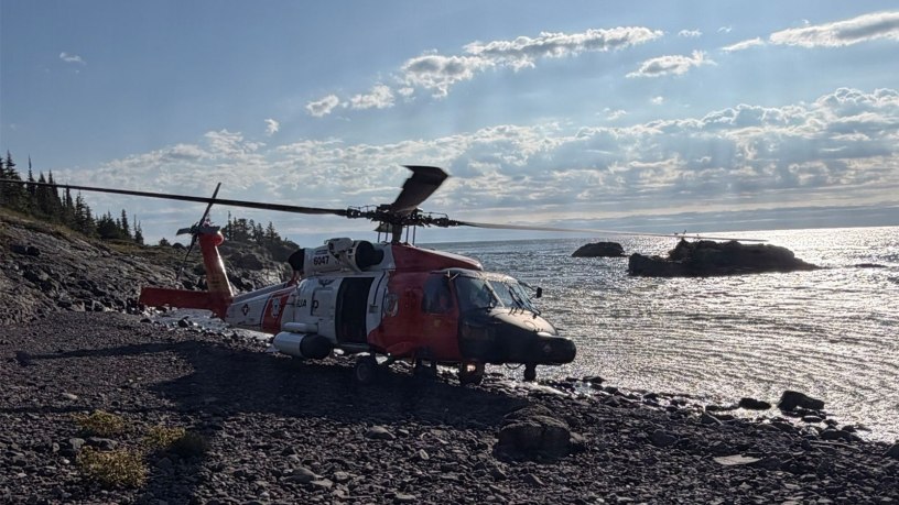 A U.S. Coast Guard Air Station Traverse City MH-60 Jayhawk helicopter sits on the shore of Isle Royale, Michigan, Sept. 11, 2026. The helicopter crew transported Michigan State Police troopers and K-9 units to the island to search for a missing hiker. (U.S. Coast Guard photo, courtesy Air Station Traverse City)
