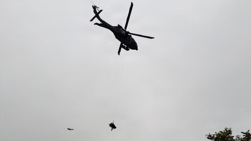 Alaska Army National Guard Staff Sgt. Steven Gildersleeve, critical care flight medic assigned to G Company, 2nd Battalion, 211th General Support Aviation Battalion, rides the hoist with an injured mountain biker in a litter during a rescue along the Winner Creek Trail near Girdwood, Alaska, Sept. 13, 2026.