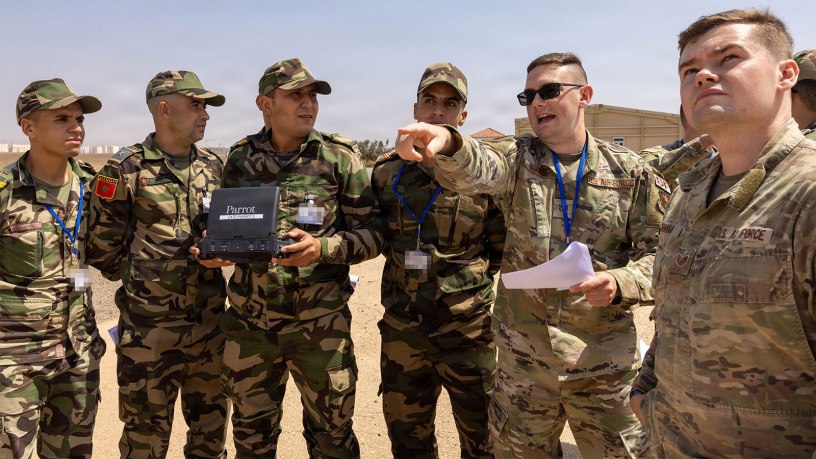 Utah Air National Guard Staff Sgt. Ryan Bigham, 151st Civil Engineer Squadron (right) and Utah Air National Guard Technical Sgt. Michael Bennion, 151st Security Forces Squadron, review instructions as counterparts from the Royal Moroccan Armed Forces pilot a small unmanned aerial system during a drone training course in Agadir, Morocco, September 16, 2026.