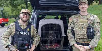 U.S. Navy Petty Officer 2nd Class Mitchell Brimner and Army Staff Sgt. Jonathan Park pose with Freedom, a bald eagle being released on to Naval Weapons Station Crane. Brimner and Park, security officers at the southern Indiana military based, worked together to save the bald eagle this past summer and get it to a rehabilitation center, ultimately saving its life. (U.S. Army photo by Sgt. Austin Goss)