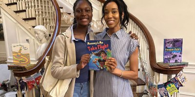 U.S. Air Force Staff Sgt. Trina Quirindongo, a member of the 113th Wing, District of Columbia Air National Guard, and her daughter, Jade, pose with their children’s book, “Mommy and Me Take Flight,” during the #ReadMoreMaryland Campaign Summer Reading Celebration at Government House in Annapolis, Maryland, June 27, 2026.
