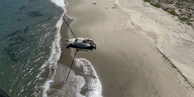 A 25-foot recreational vessel sits grounded on a beach on Santa Rosa Island, California, Sept. 24, 2026. A Coast Guard Air Station Ventura aircrew rescued one person from the island and took them to Camarillo Airport for evaluation by Ventura County Fire Department personnel. (U.S. Coast Guard courtesy photo)