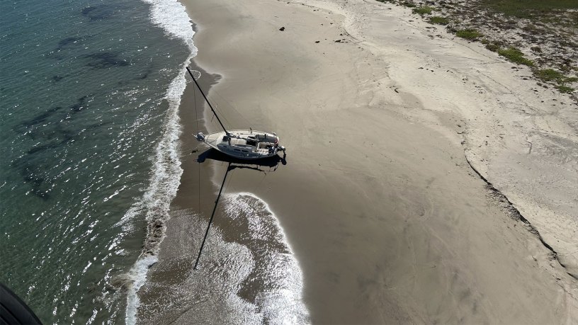 A 25-foot recreational vessel sits grounded on a beach on Santa Rosa Island, California, Sept. 24, 2026. A Coast Guard Air Station Ventura aircrew rescued one person from the island and took them to Camarillo Airport for evaluation by Ventura County Fire Department personnel. (U.S. Coast Guard courtesy photo)