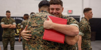 U.S. Marine Corps Lance Cpl. Daniel Capes, company clerk, Bravo Company, Marine Barracks Washington, embraces another Marine after receiving an award at Marine Barracks Washington, D.C., Sept. 23, 2026.