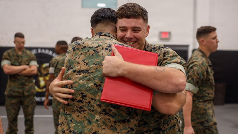 U.S. Marine Corps Lance Cpl. Daniel Capes, company clerk, Bravo Company, Marine Barracks Washington, embraces another Marine after receiving an award at Marine Barracks Washington, D.C., Sept. 23, 2026.