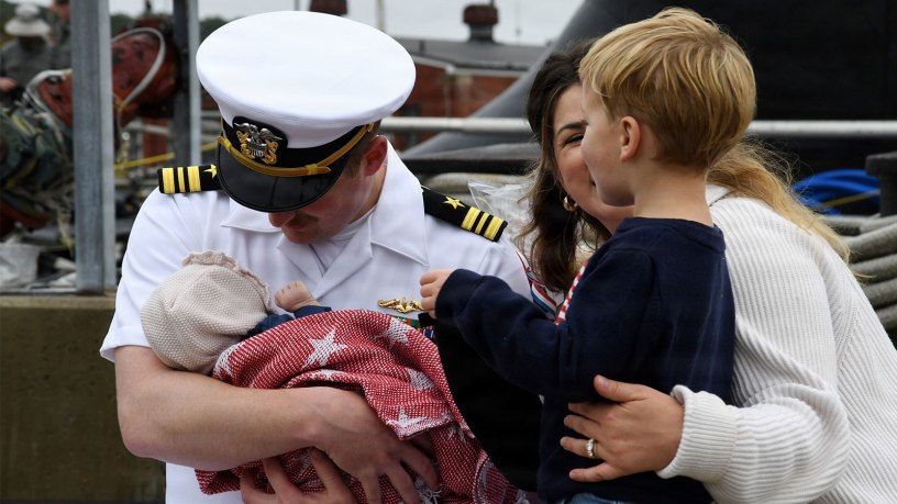 Lt. Cmdr. Charles Linder meets his new daughter, Charlotte, for the first time as the nuclear-powered fast-attack submarine USS Idaho (SSN 799) returns to Naval Submarine Base New London in Groton, Conn., Sept. 28, 2026, following a four-month deployment to the U.S. European Command area of responsibility.