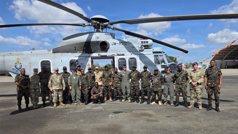 U.S. Air Force and Tanzania People’s Defence Force personnel pose beside a Tanzanian military helicopter during an aerial patient movement knowledge exchange at the 603rd Air Transport Station.