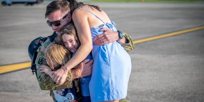 A Soldier assigned to the Connecticut National Guard's 1-102nd Infantry Regiment hugs his children after returning home from a deployment to the Middle East Aug. 19, 2026. Photo by Timothy Koster.