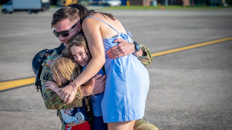A Soldier assigned to the Connecticut National Guard's 1-102nd Infantry Regiment hugs his children after returning home from a deployment to the Middle East Aug. 19, 2026. Photo by Timothy Koster.