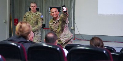 Alaska Army National Guard Staff Sgt. Marc Marmeto, a mass communication specialist with the 134th Public Affairs Detachment, right, demonstrates mobile communication techniques as Wyoming Army National Guard Sgt. Joseph Burns, a mass communication specialist with the 197th Public Affairs Detachment, looks on during a public affairs professional development exchange with Kosovo Police at Camp Bondsteel, Kosovo, Sept. 25, 2026.