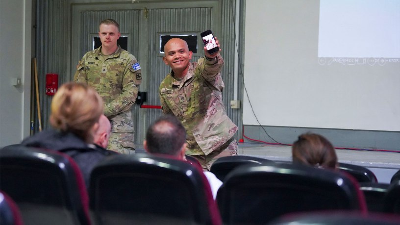 Alaska Army National Guard Staff Sgt. Marc Marmeto, a mass communication specialist with the 134th Public Affairs Detachment, right, demonstrates mobile communication techniques as Wyoming Army National Guard Sgt. Joseph Burns, a mass communication specialist with the 197th Public Affairs Detachment, looks on during a public affairs professional development exchange with Kosovo Police at Camp Bondsteel, Kosovo, Sept. 25, 2026.