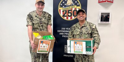Chief Mass Communication Specialist Jose Jaen, right, Navy Region Hawaii’s public affairs leading chief petty officer, and Electronics Technician (Nuclear), 1st Class Ian Young from Pearl Harbor Naval Shipyard and Intermediate Maintenance Facility (PHNSY & IMF) hold some of the canned goods and pantry items donated by PHNSY & IMF for the month-long Summer Food Drive at Joint Base Pearl-Harbor-Hickam, Hawaii, Sept. 30, 2026.
