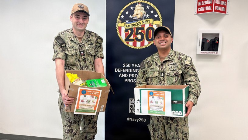 Chief Mass Communication Specialist Jose Jaen, right, Navy Region Hawaii’s public affairs leading chief petty officer, and Electronics Technician (Nuclear), 1st Class Ian Young from Pearl Harbor Naval Shipyard and Intermediate Maintenance Facility (PHNSY & IMF) hold some of the canned goods and pantry items donated by PHNSY & IMF for the month-long Summer Food Drive at Joint Base Pearl-Harbor-Hickam, Hawaii, Sept. 30, 2026.