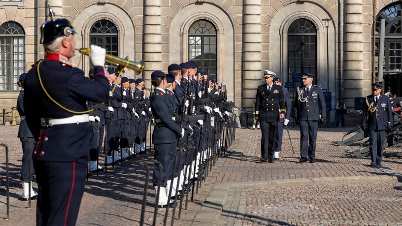 Cmdr. William Burke, center, commanding officer of Arleigh Burke-class guided-missile destroyer USS Paul Ignatius (DDG 117), observes Swedish guards at Stockholm Royal Palace in Stockholm, Sweden, Oct. 1, 2026.
