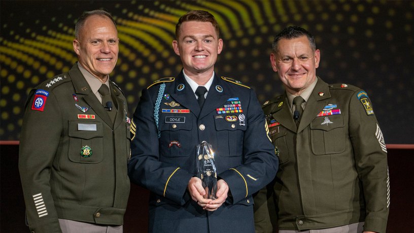 U.S. Army Staff Sgt. Colin Doyle, assigned to the 75th Ranger Regiment, is announced as the 2026 NCO of the Year by U.S. Army Vice Chief of Staff, Gen. Christopher LaNeve, and Sgt. Maj. of the Army Michael Weimer at the 2026 AUSA Annual Meeting and Exposition in Washington, D.C., Oct. 12, 2026. (U.S. Army photo by Staff Sgt. Alexander Nieves)