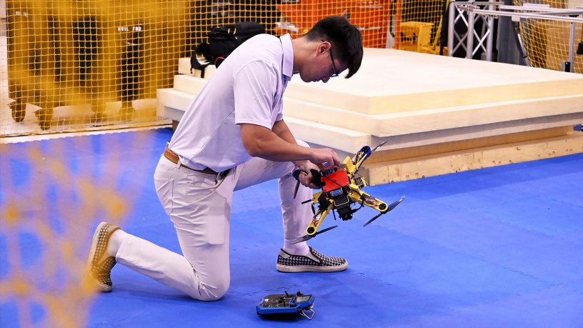 A Navy engineer prepares a small unmanned system for indoor testing at the Naval Air Warfare Center Aircraft Division (NAWCAD).